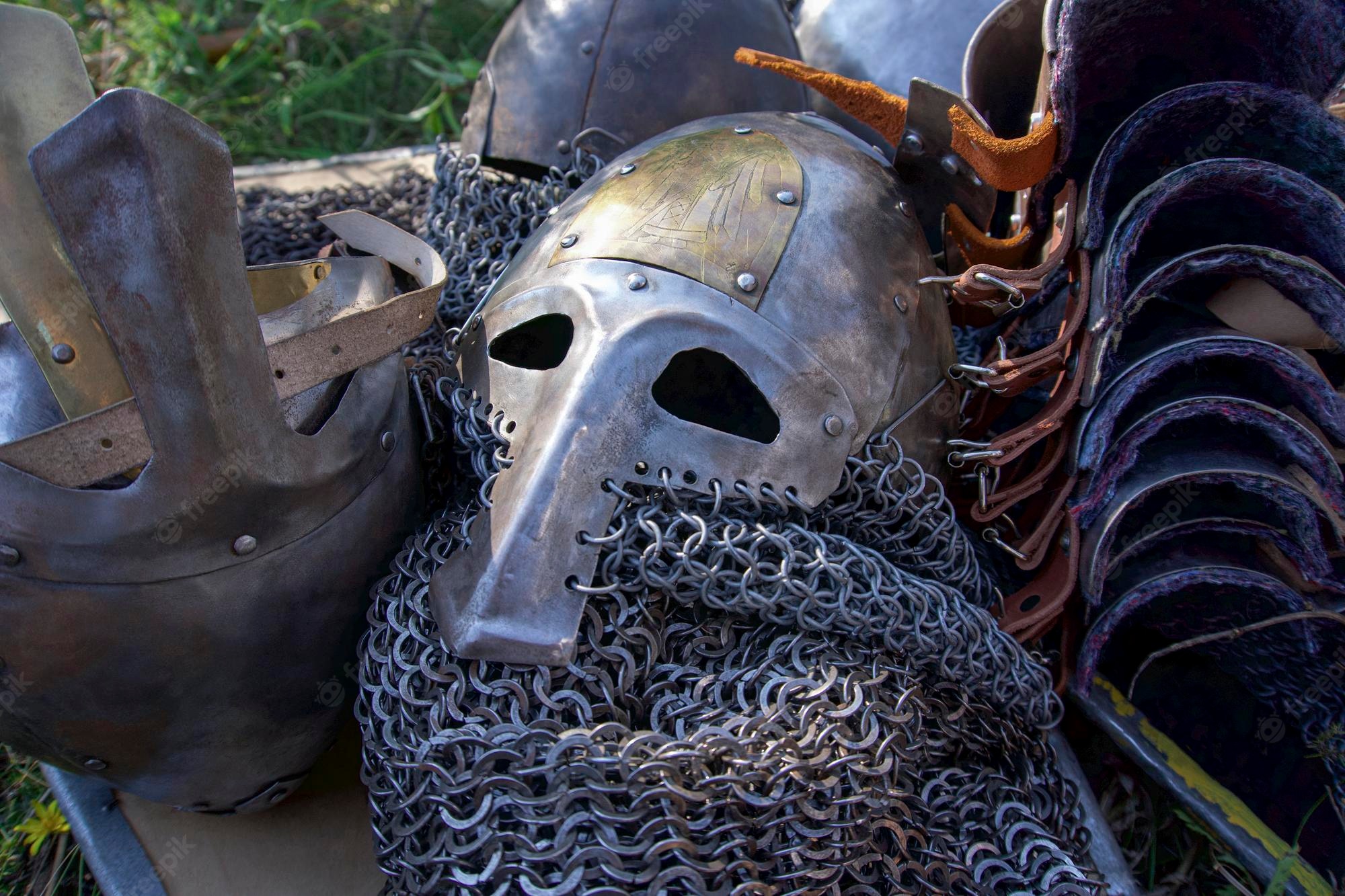 Iron armor helmet, chain mail suit, and belts placed on grass