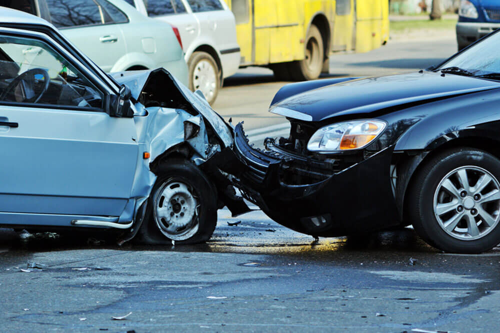 A car accident between a grey car and a black car on the road