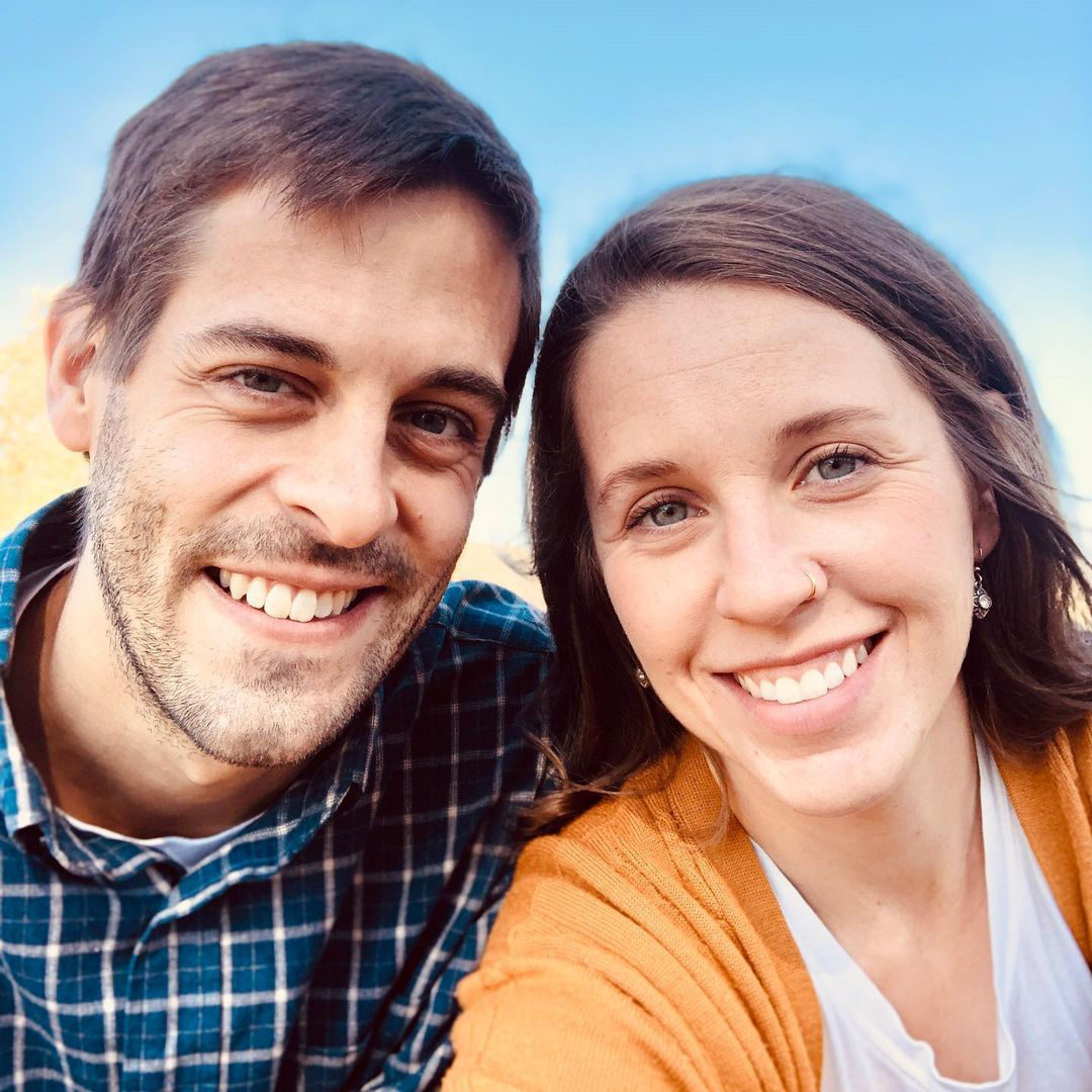 With a skyblue background, Jill and Derick Dillard is smiling genuinely