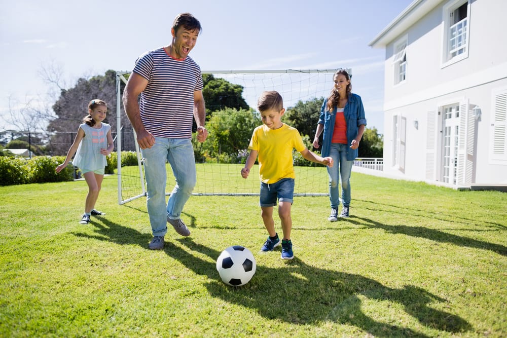 A family enjoying playing football in the garden