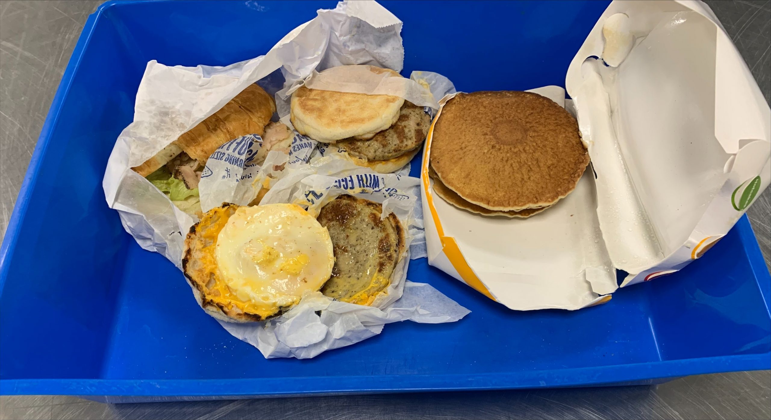 The confiscated foods discovered by the authorities are a ham croissant and two egg and sausage McMuffins in a blue container