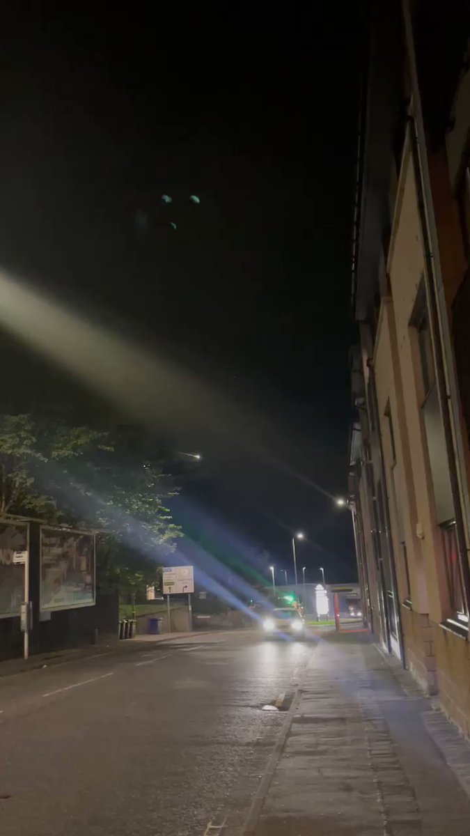 A street at night in UK with fireball visible in the night sky