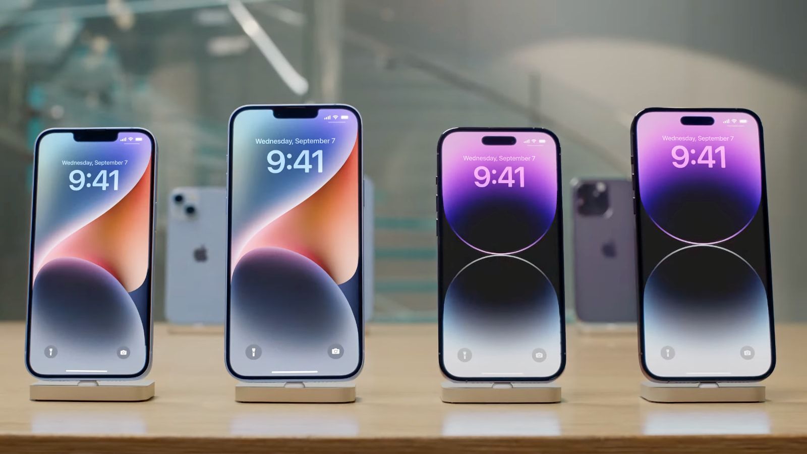 Four Iphone devices displayed on a counter