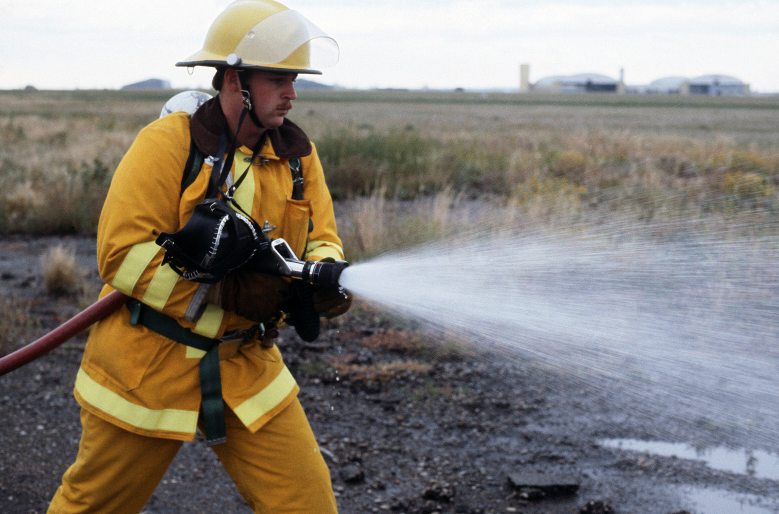 A firefighter holding a water hose during an accident