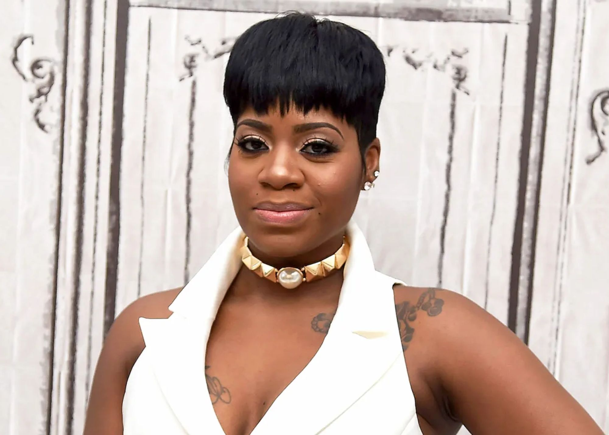 Fantasia is dressed in a white sleeveless dress and a pearl necklace around her neck