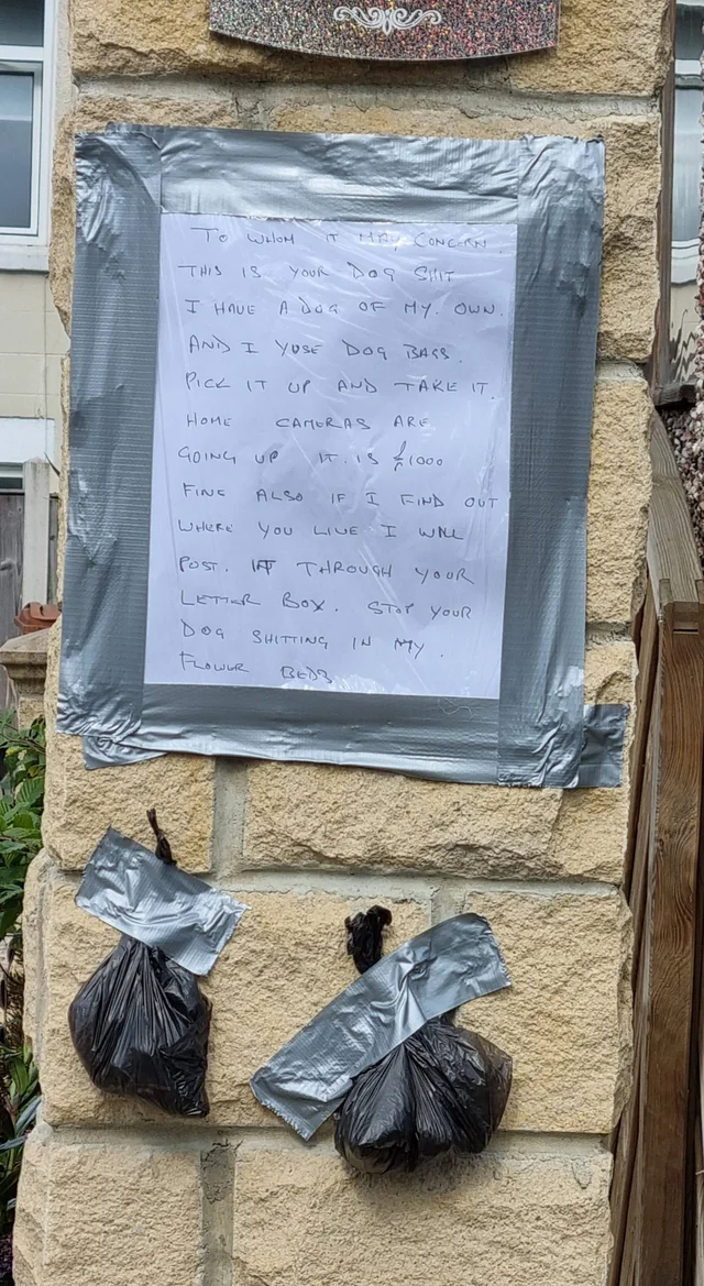 A note and two packets of dog poop taped on a wall