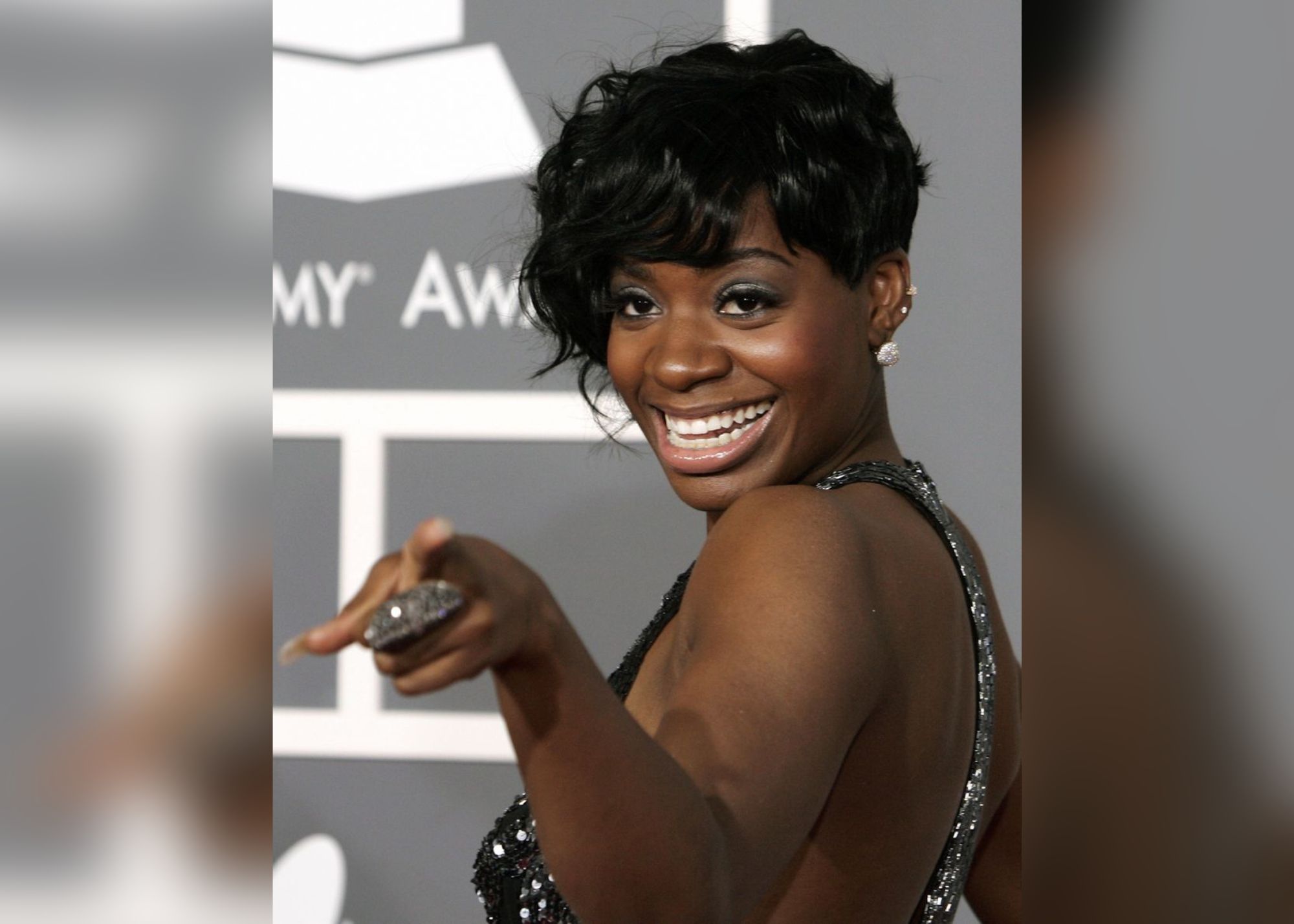 Fantasia smiles warmly while pointing her finger at someone