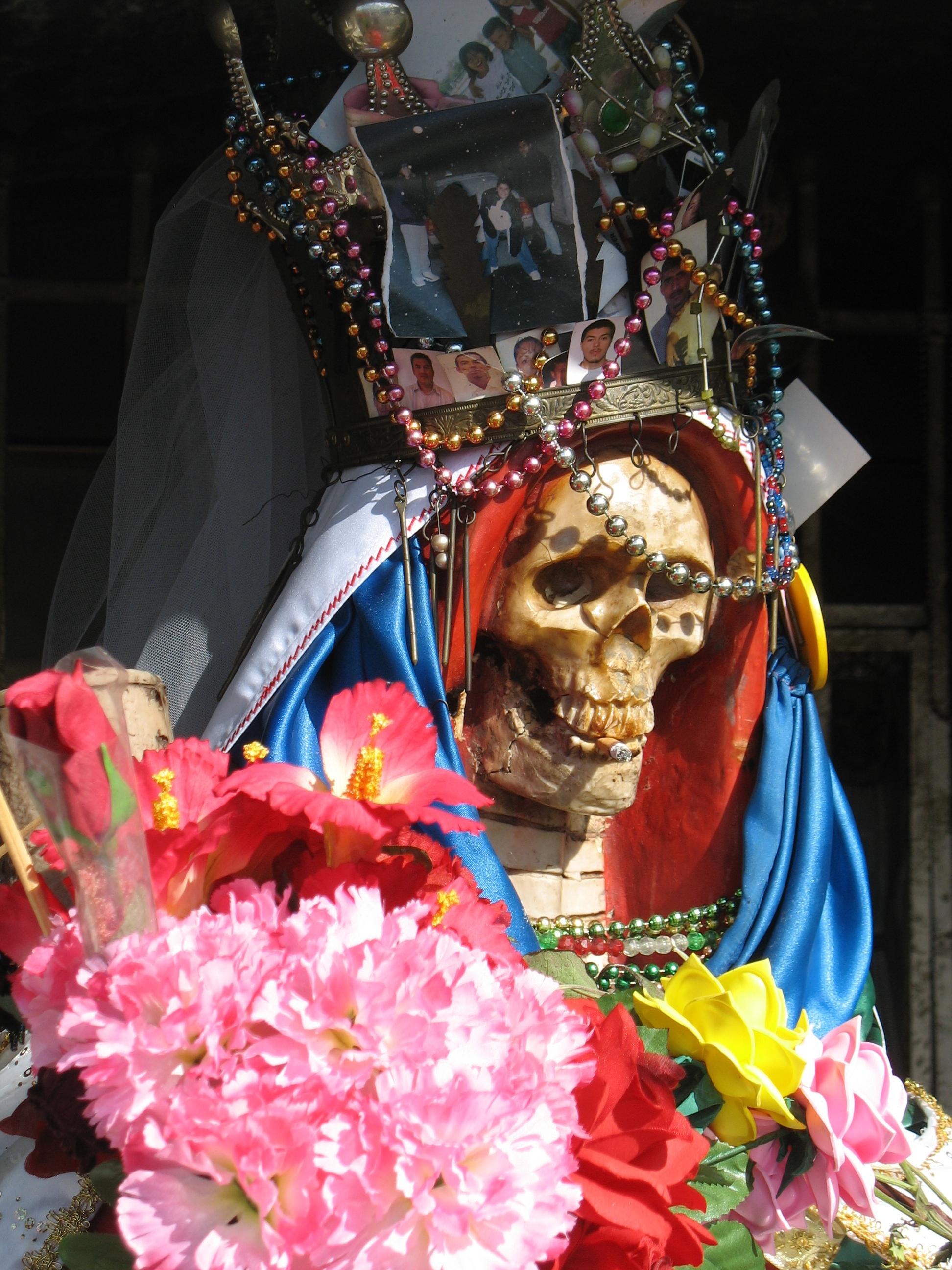A skeleton decorated with flowers and jewelry symbolizing Santa Muerte