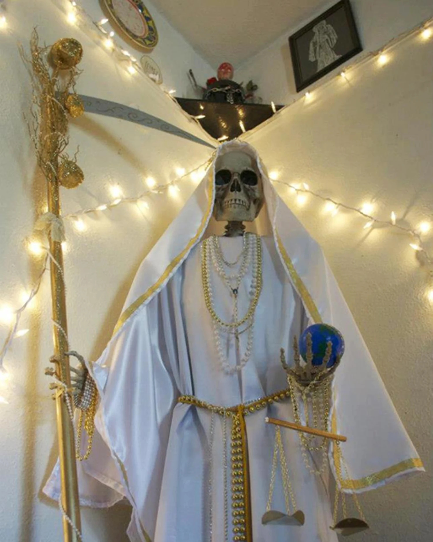 A skeleton wearing a white cloak, holding an ax, and wearing jewelry symbolizing Santa Muerte