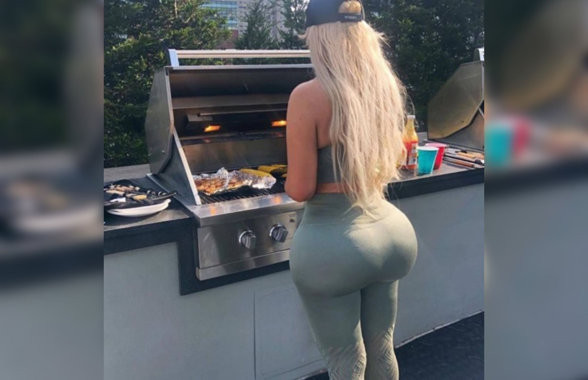 A woman facing backward while cooking shows her big and large ass