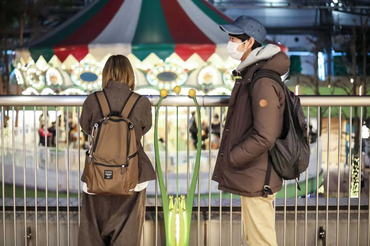 Shoji Morimoto standing next to a lady in an amusement park