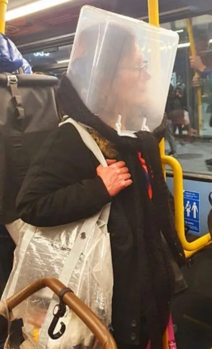A woman wearing a transparent plastic bucket in bus to prevent being infected