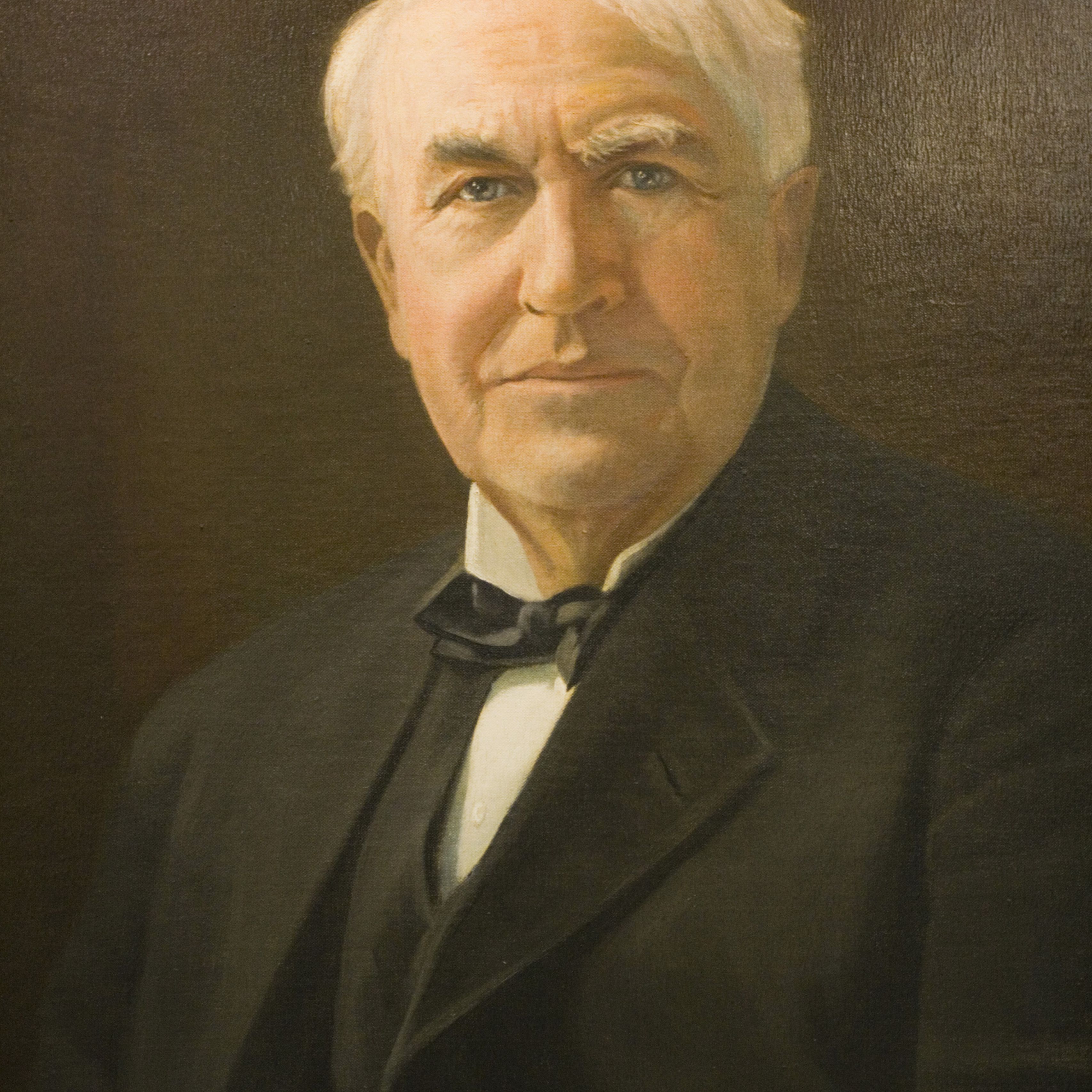 A portrait of Thomas Alba Edison wearing a black suit