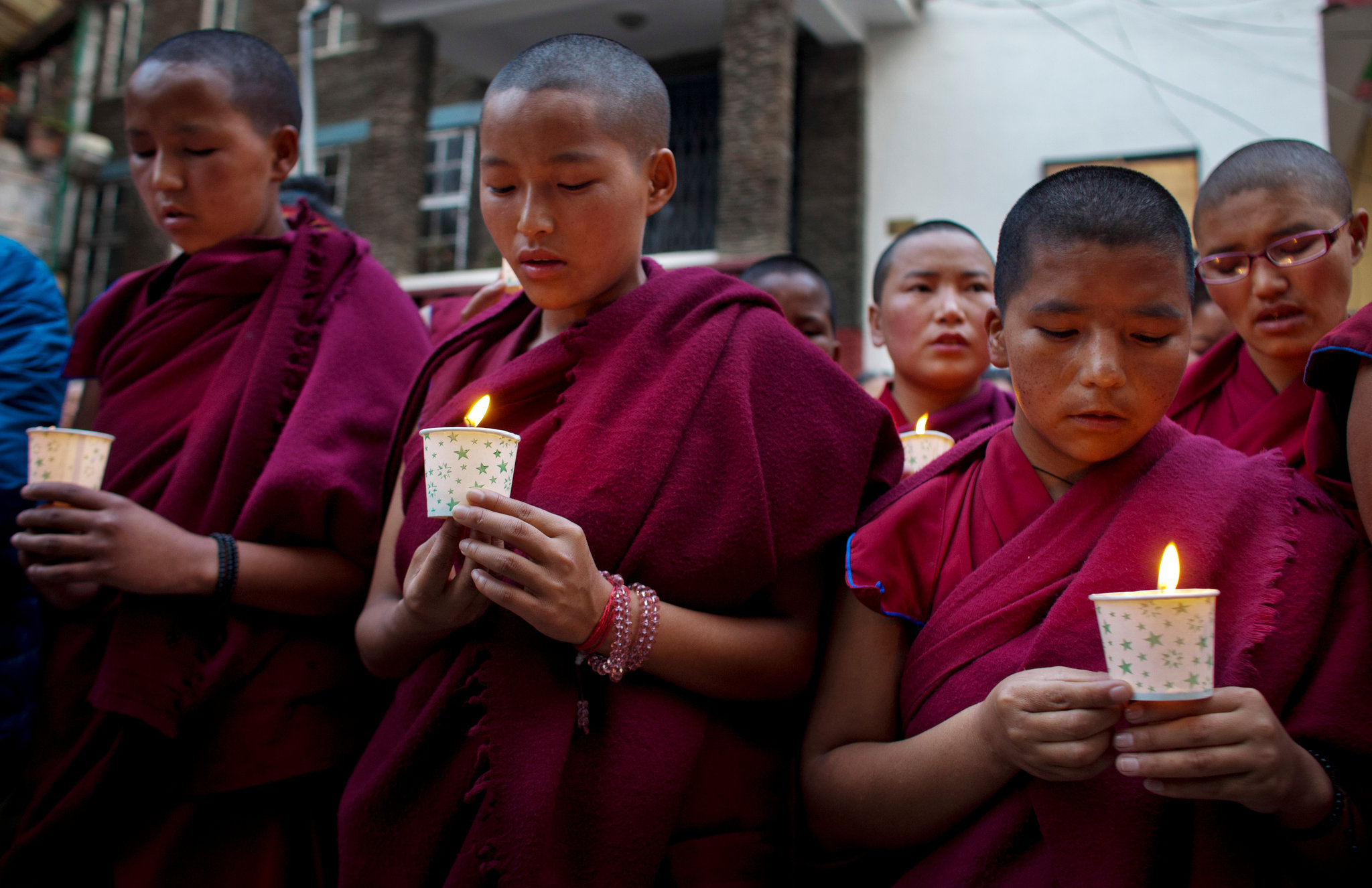 Young Monks holding candles and praying