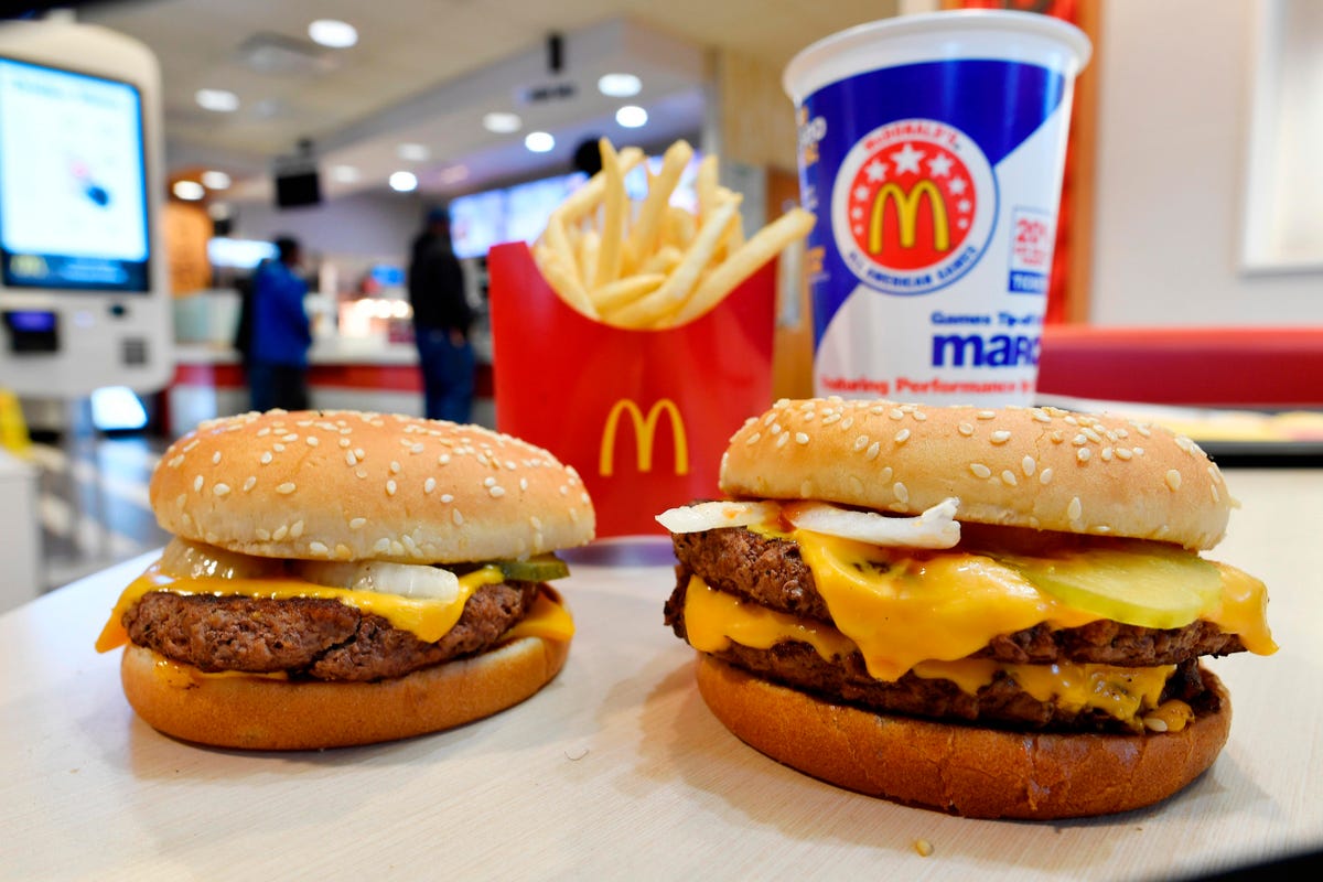 Two Mcburgers with fries and a glass of soft-drink