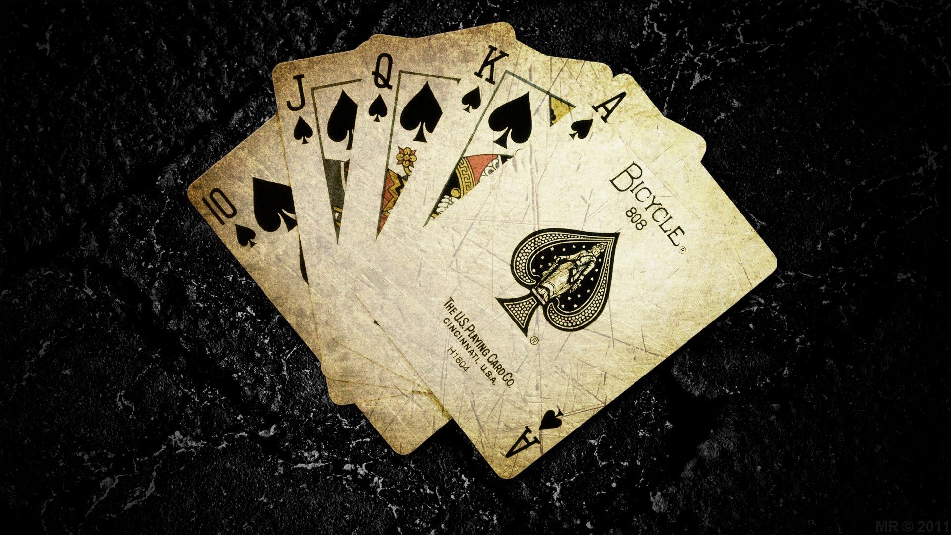 Old poker cards placed on a black surface