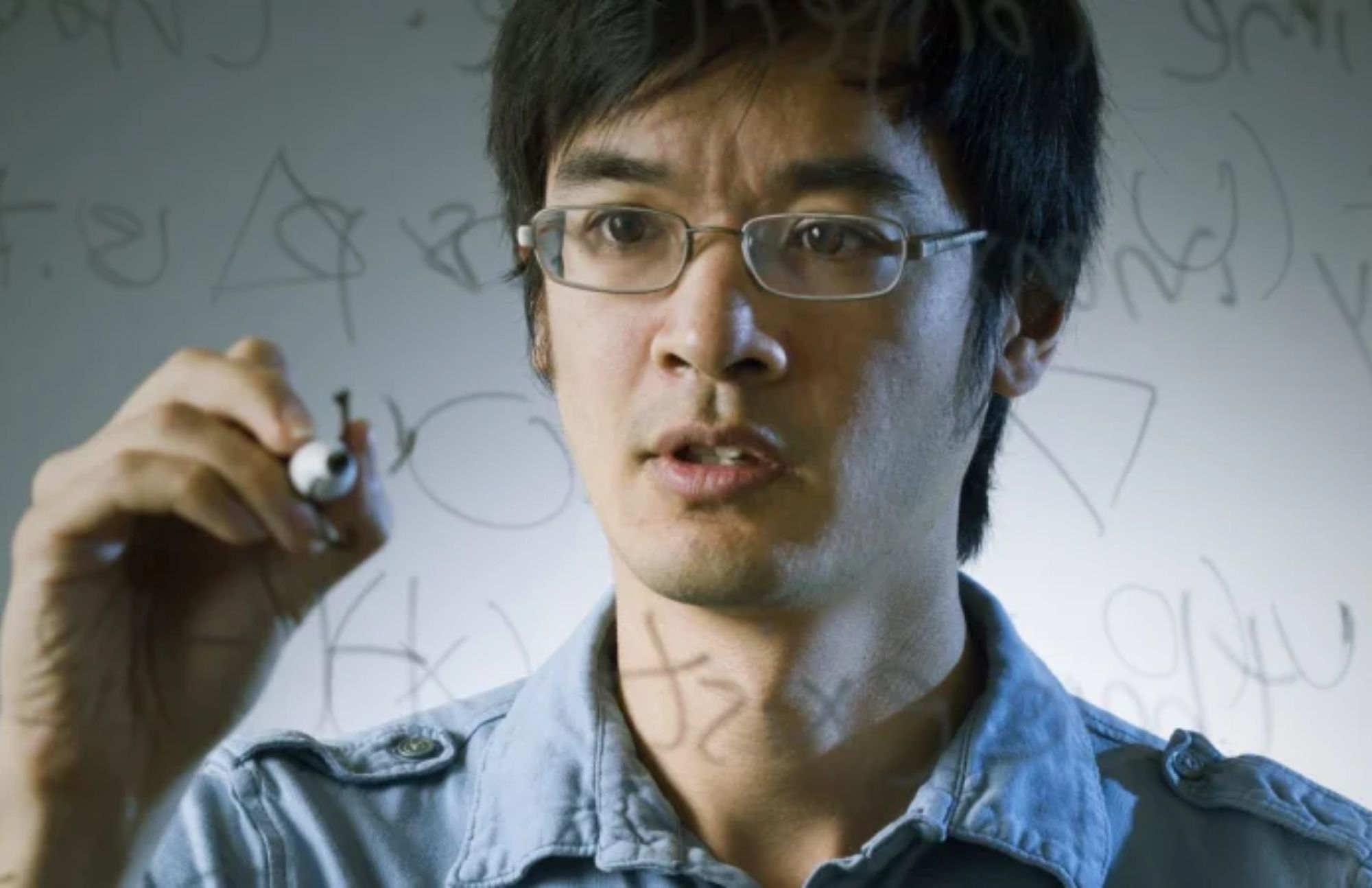 Terence Tao is writing equations in transparent architectural board