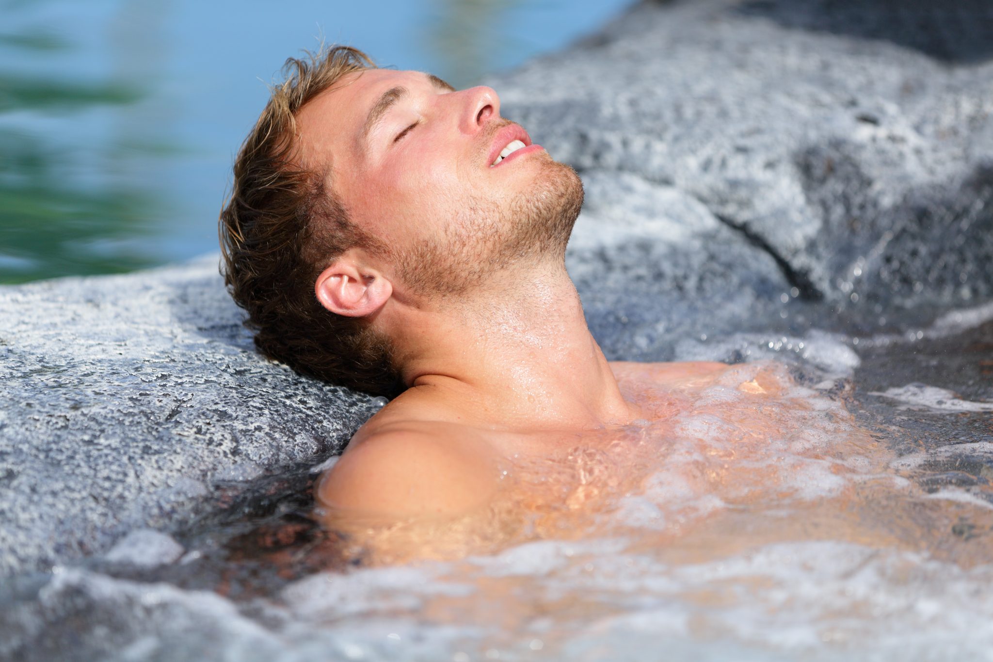 A man bathing in a jacuzzi with his eyes closed