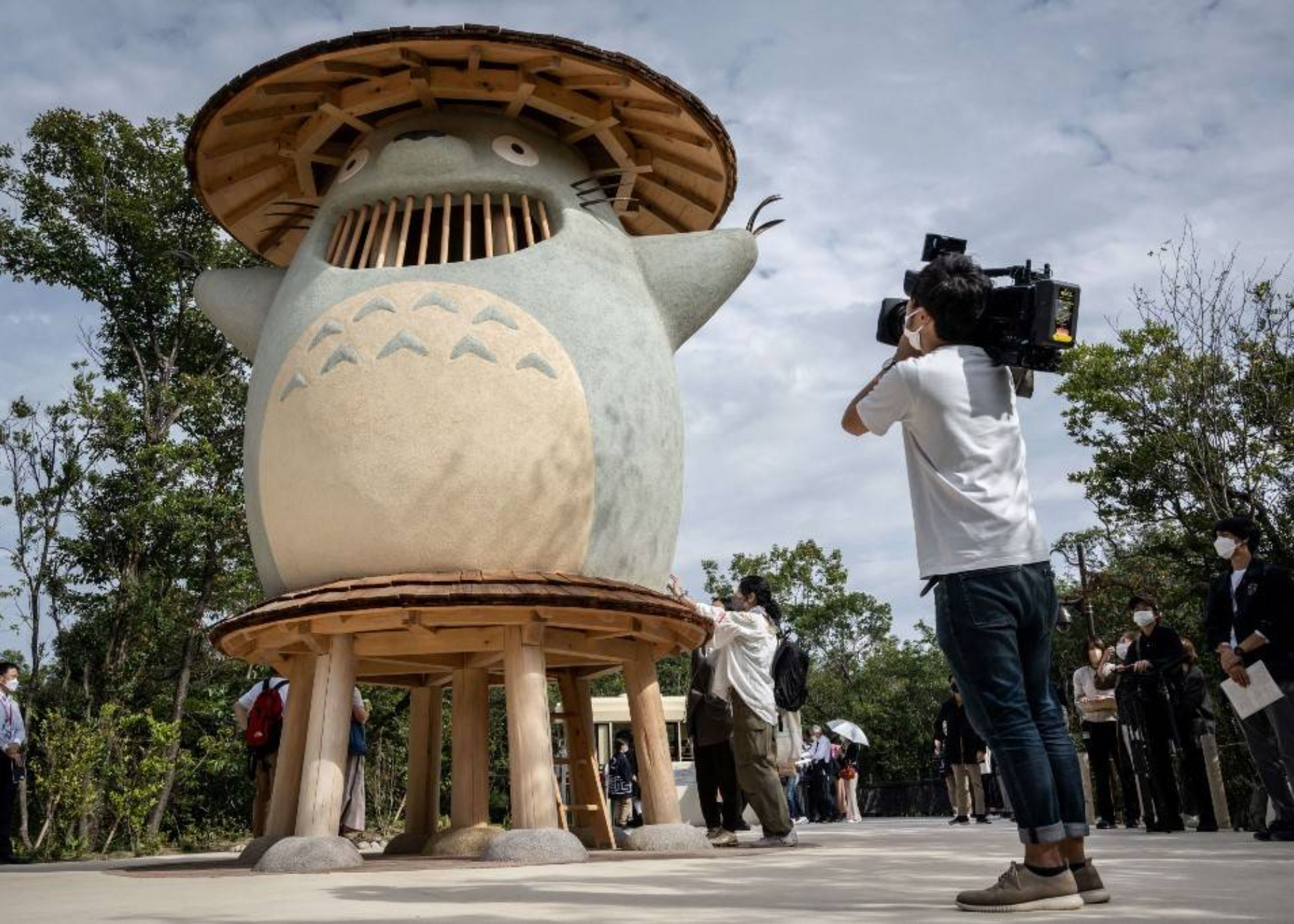 At Dondoko Forest, a member of the press takes a video of an exhibit of the Ghibli character "Totoro"