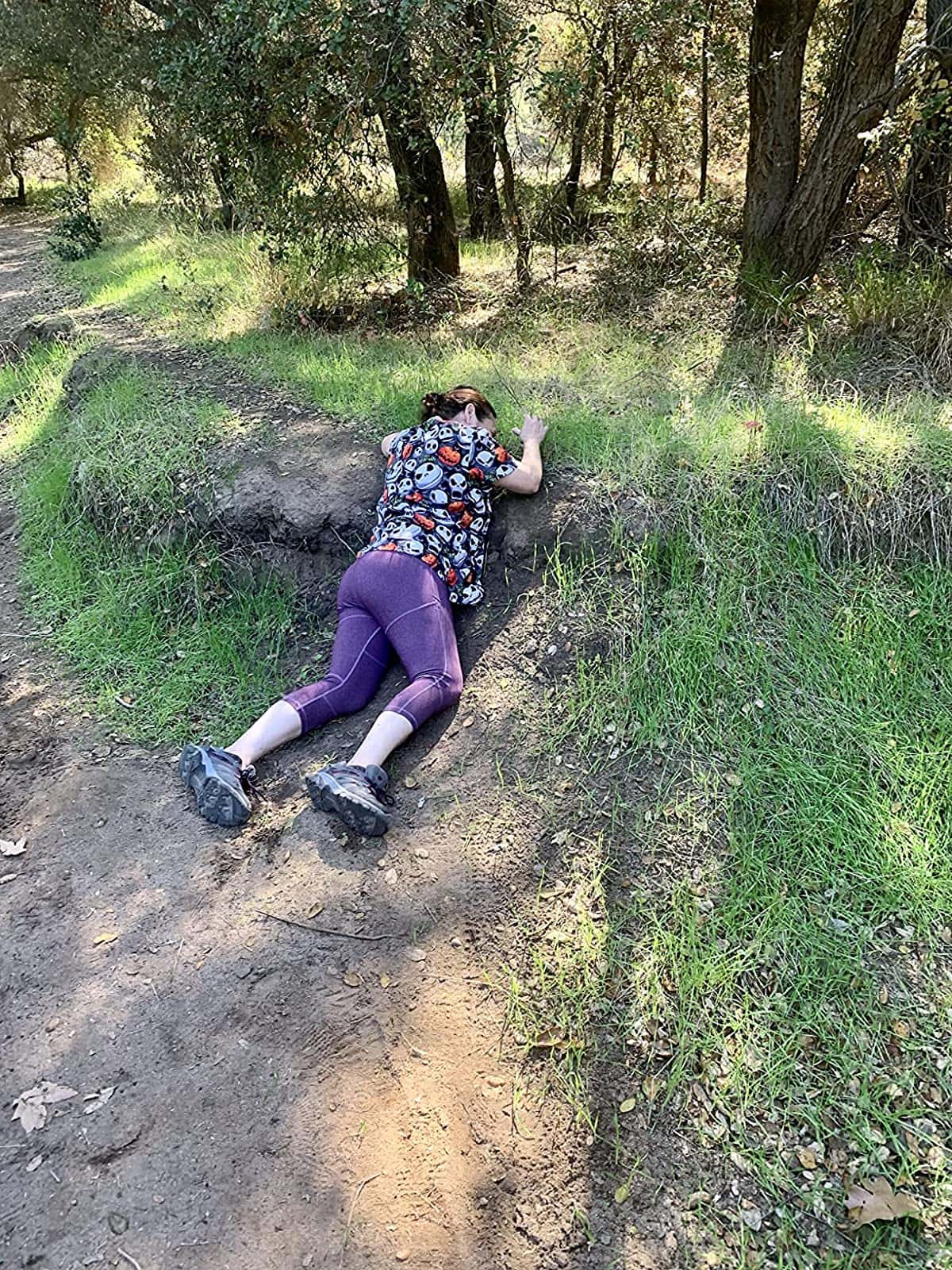 A woman wearing a violet leggings to imitate the woman who accidentally rolled down in a mountain 