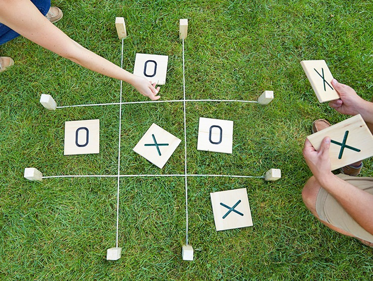 Two persons playing giant tic-tac-toe on the ground