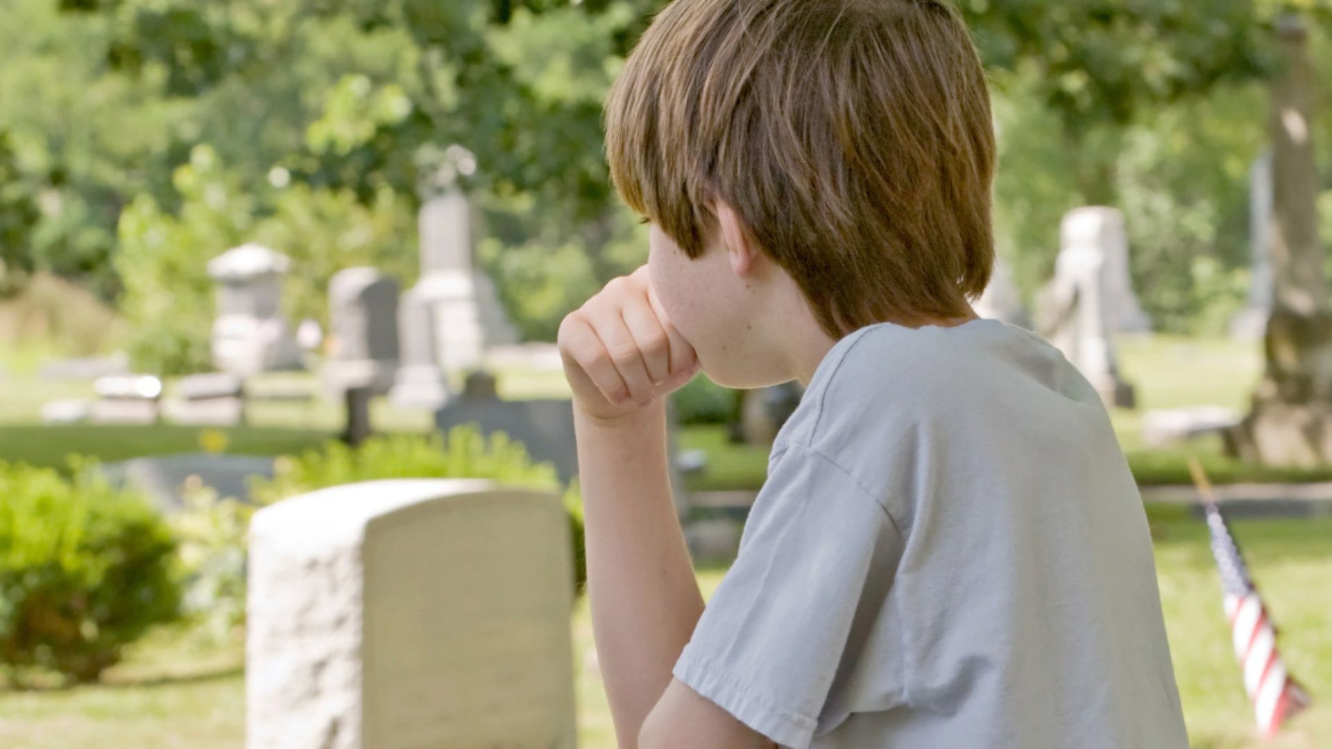 Boy Wearing White Shirt Sitting Near Grave