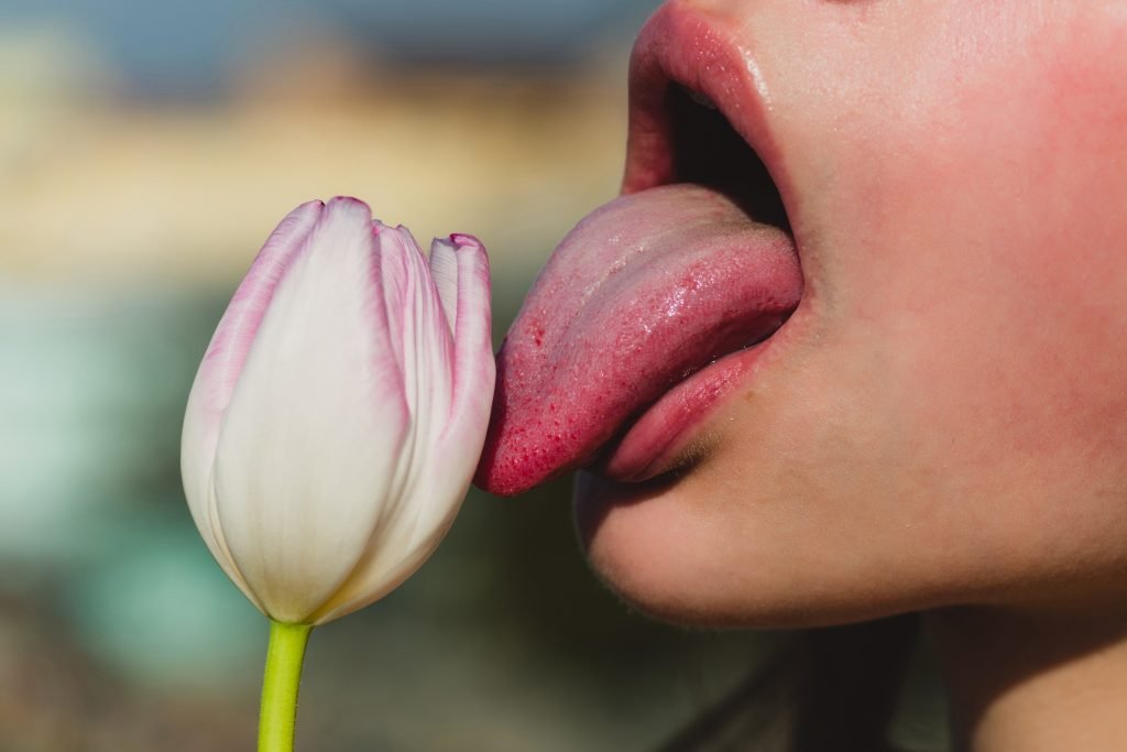 A Woman Licking A Tulip