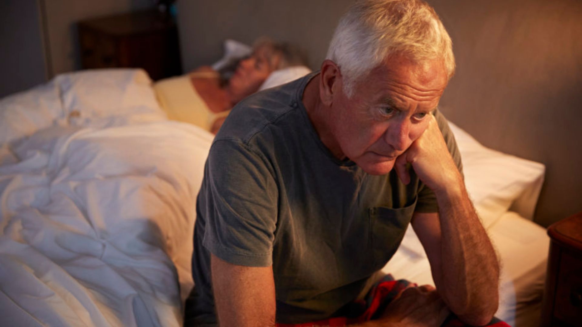 Old Man Sitting On Bed Depressed about something