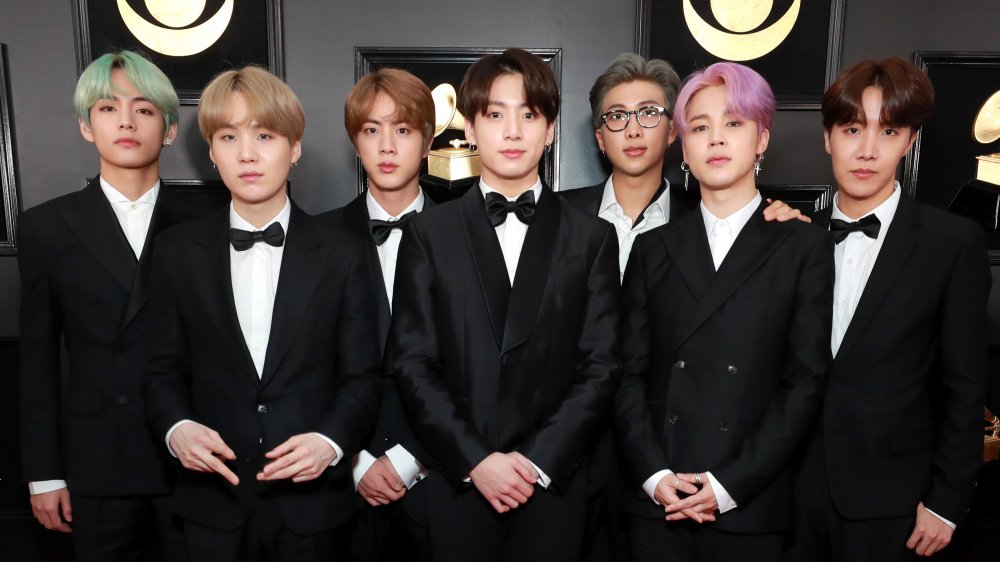 BTS members in suits posing during an awards show