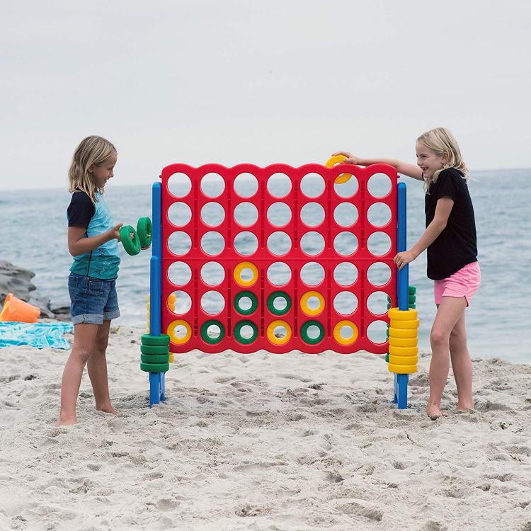 Two girls playing a giant red game on the baech