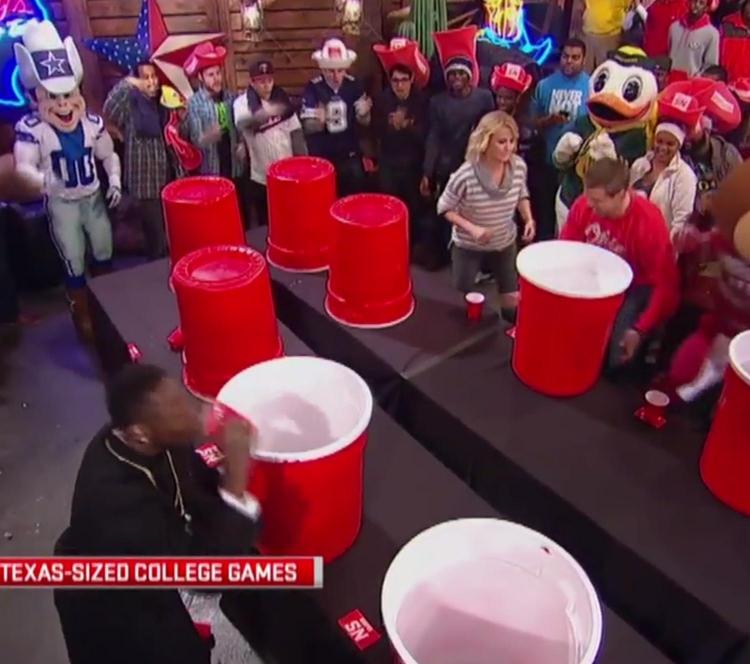 A crowd playing giant card red cups flipping game