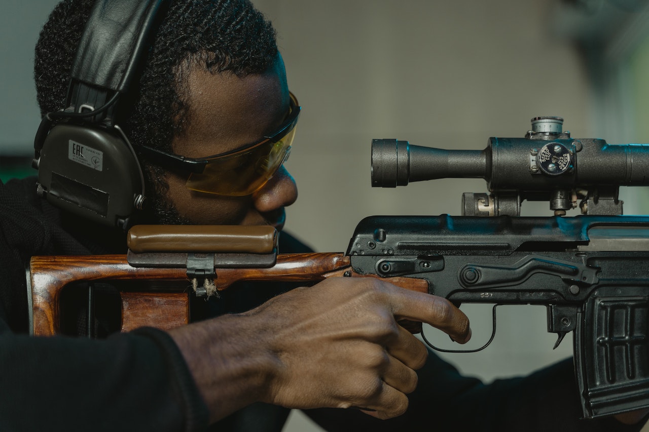 A Focused Man with a rifle and headphones Aiming for the Target