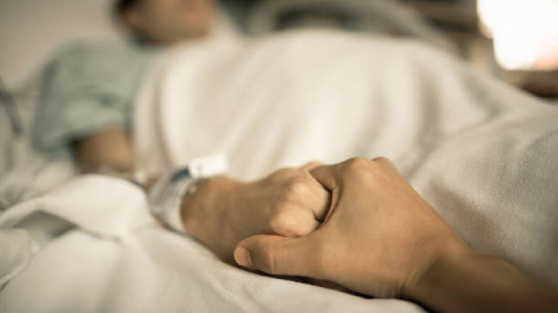 A Loved One Is Holding The Patient's Hands Tightly