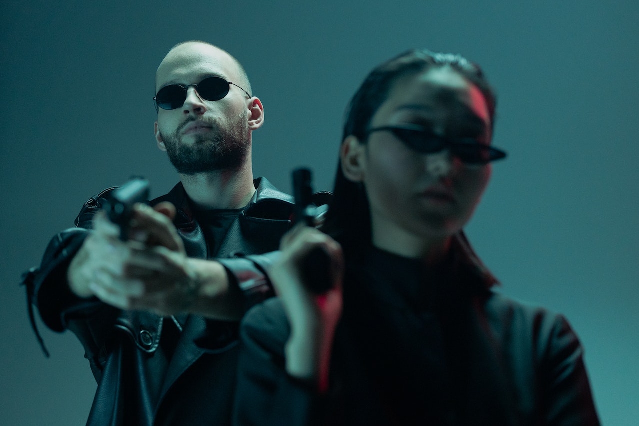 A Man and a Woman Holding Guns And Ready To Shoot