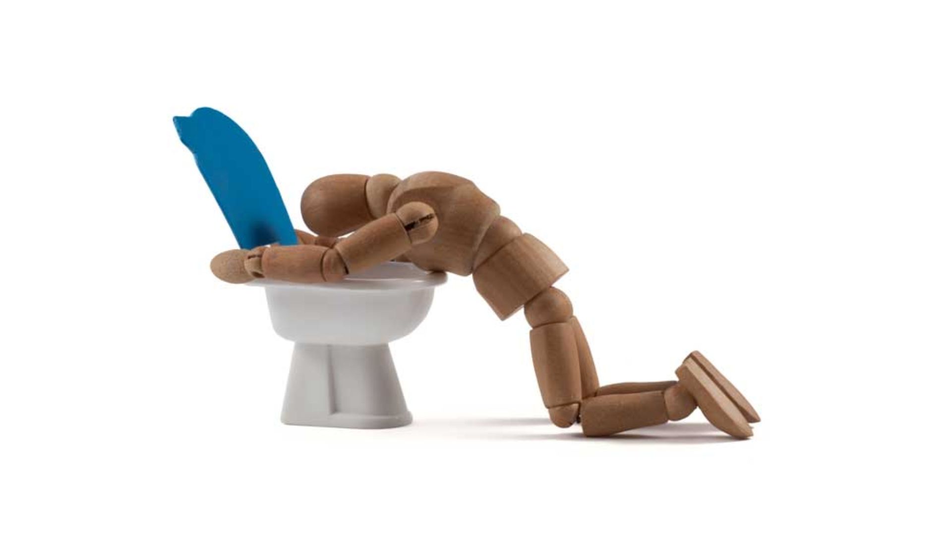 A Wooden Toy Vomiting On The Toilet Bowl