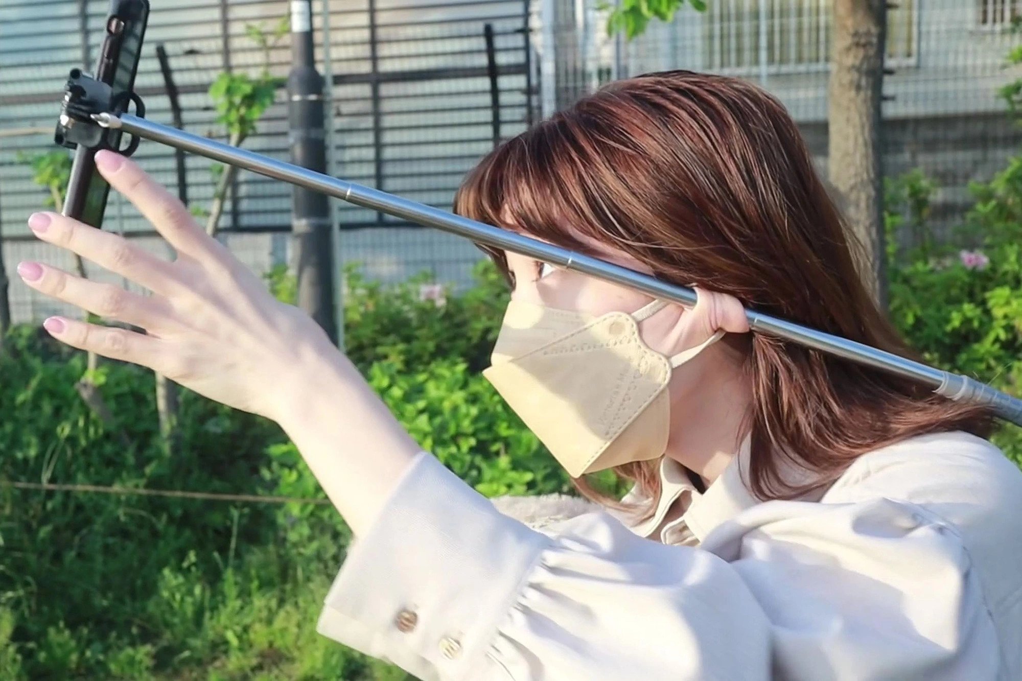 Ayumi Tkada holding a selfie stick in her ears
