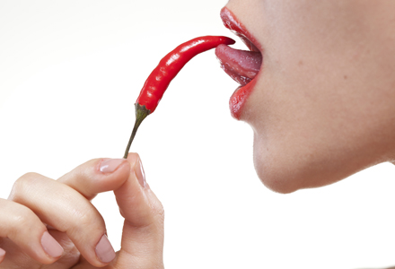 A woman licking a chili