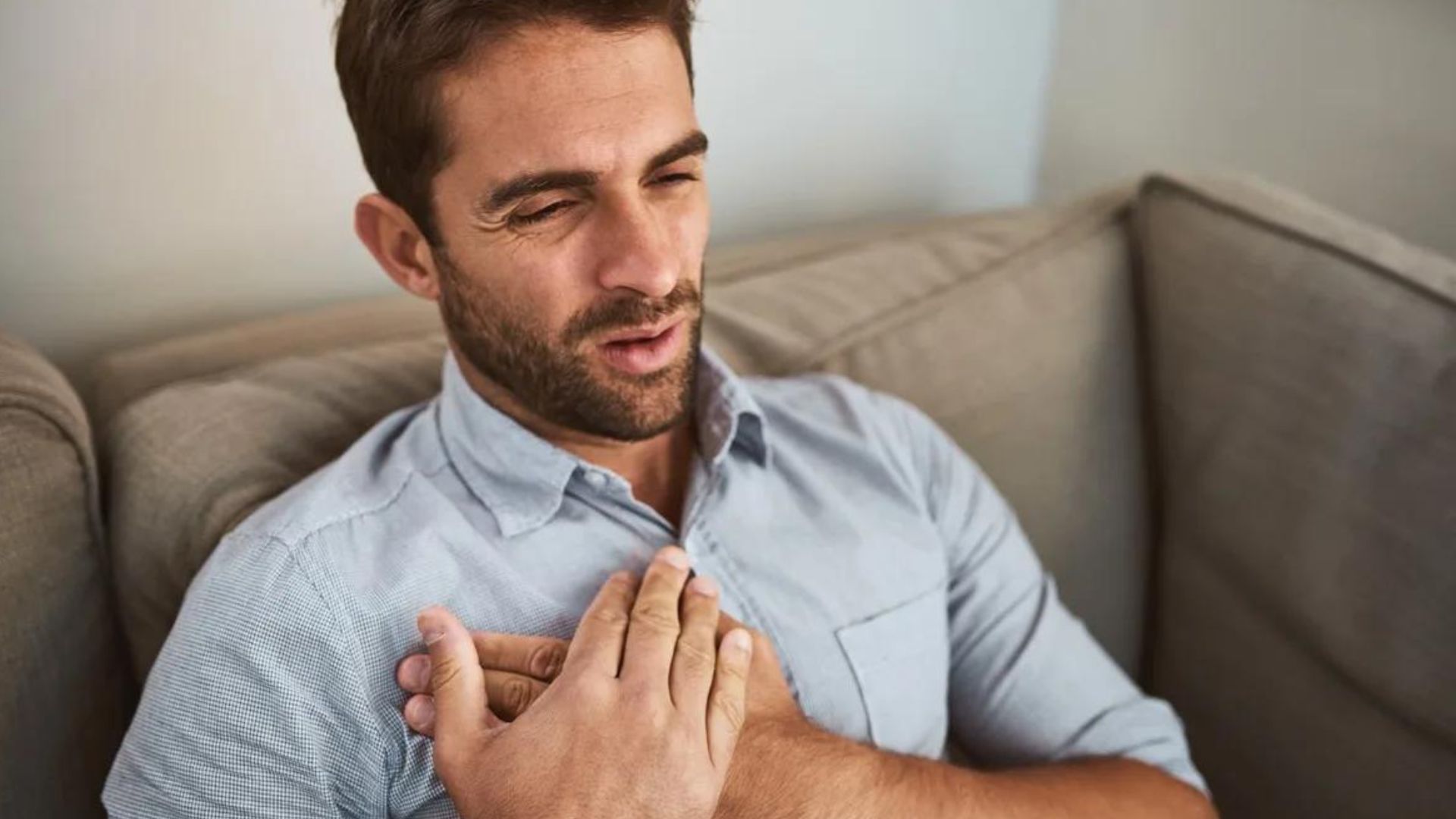 Man On Couch Having Chest Pain