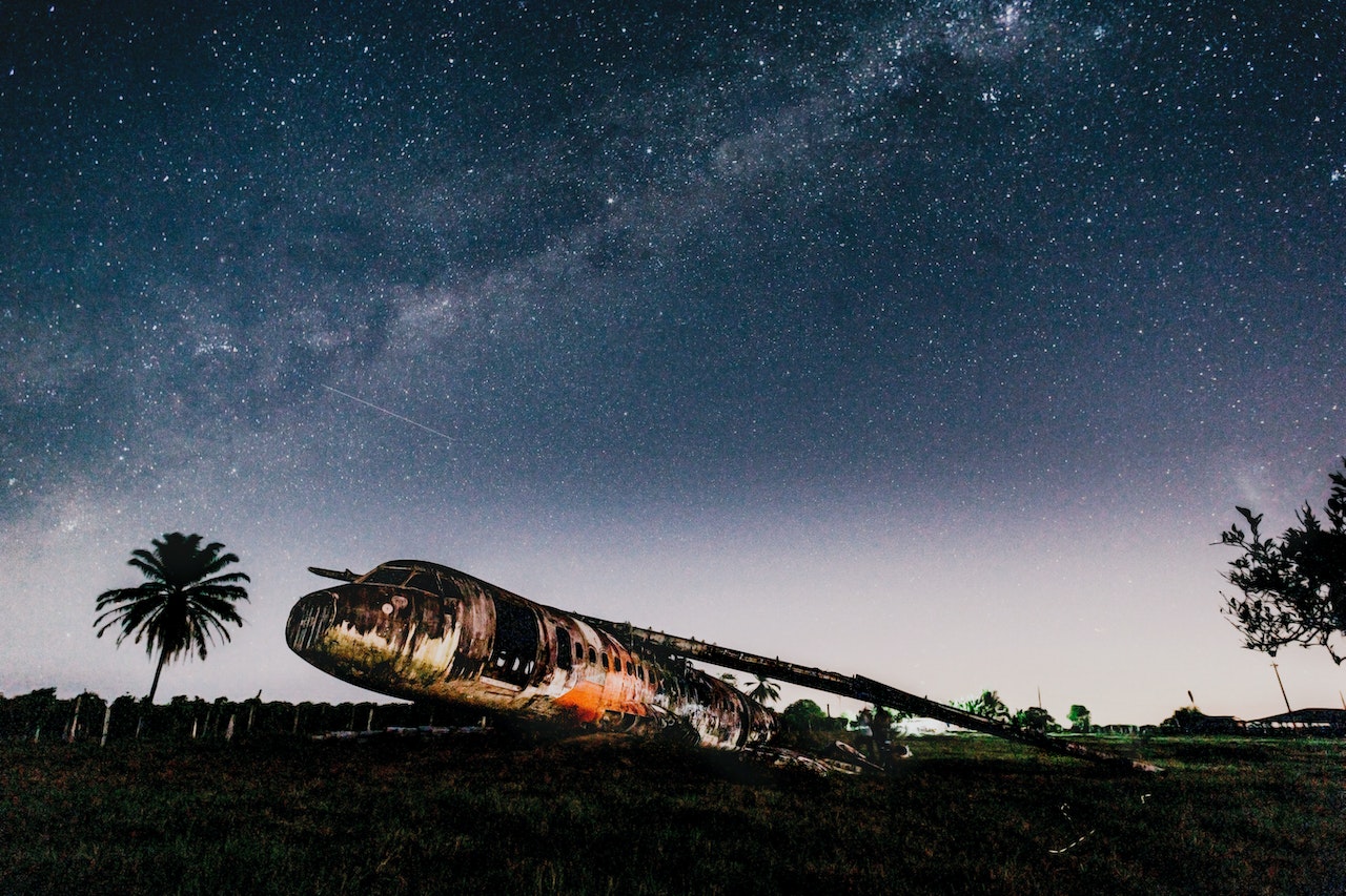 Crashed airplane on land under bright sky in evening