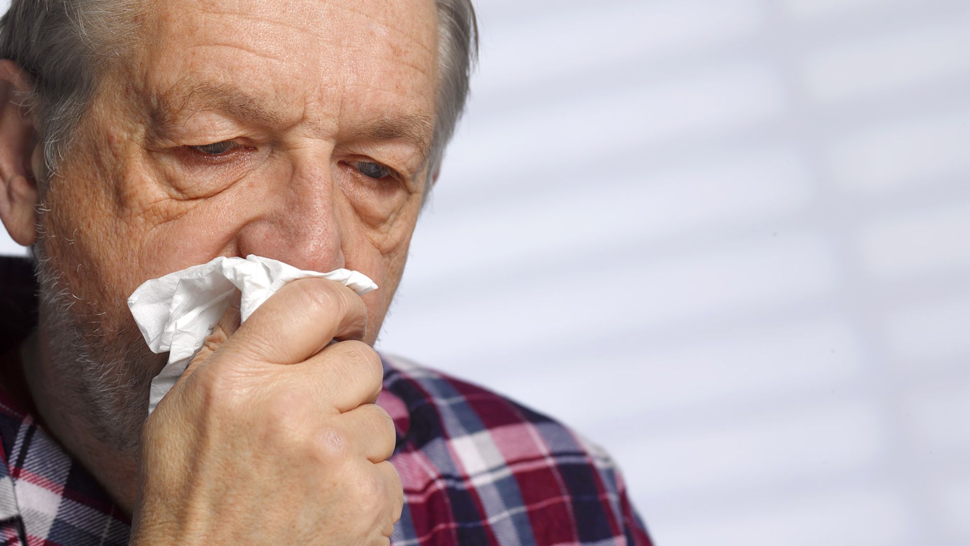 Old Man Covering Mouth With Tissue