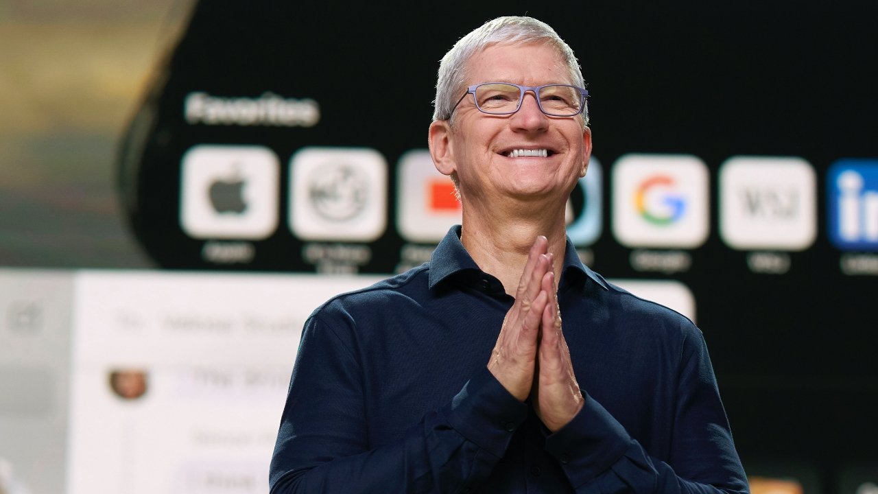 Tim Cook wearing a dark blue long sleeves and is smiling in the camera