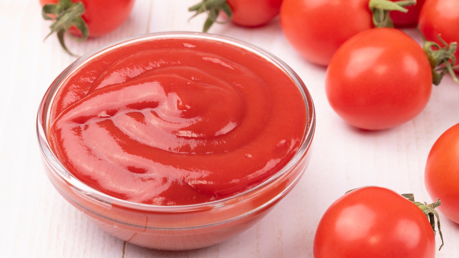 A bowl of ketchup and some tomatoes