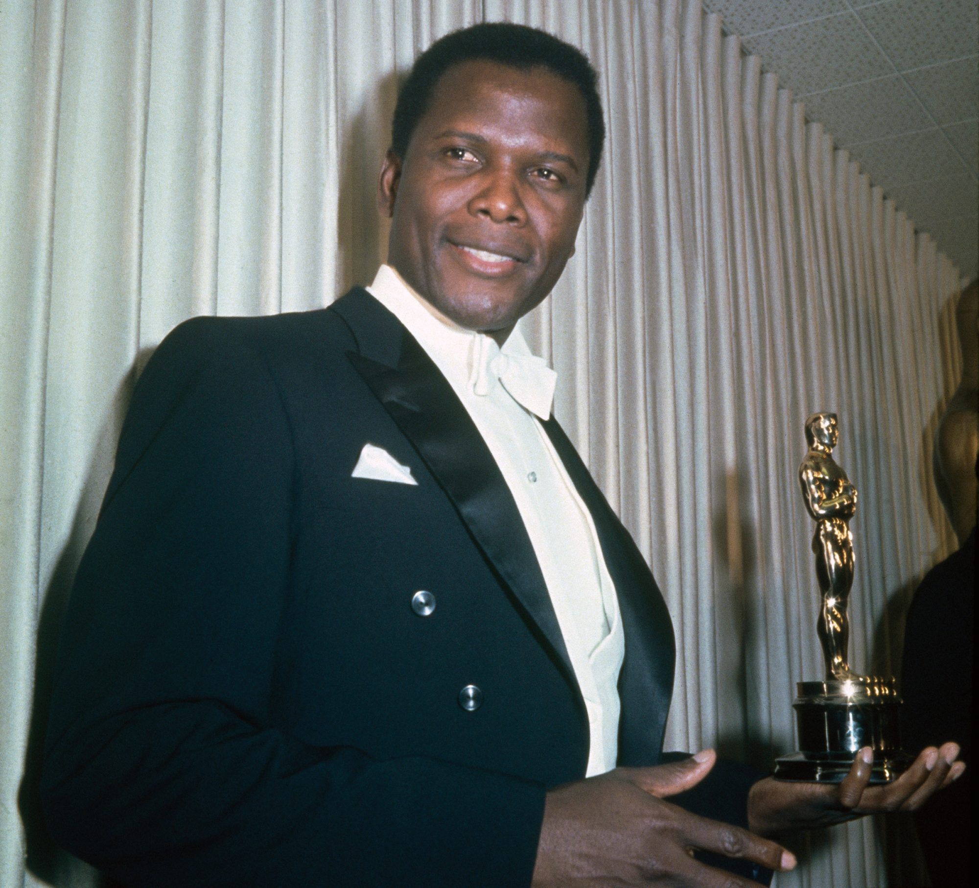 Sidney Poitier holding his award in his left hand