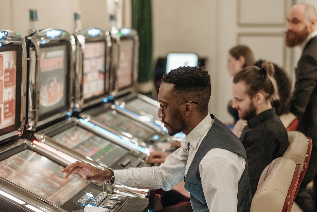 Men Playing Slot Machines in the Casino
