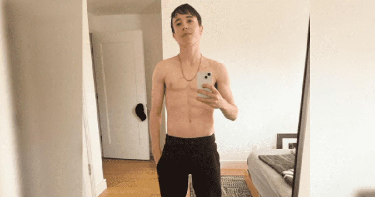 Elliot Page taking a selfie in the mirror while topless