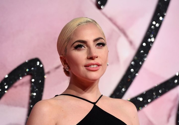 Lady Gaga wearing a black dress and diamond earrings