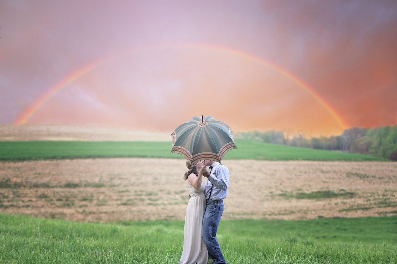Couple Holding Umbrella While Kissing