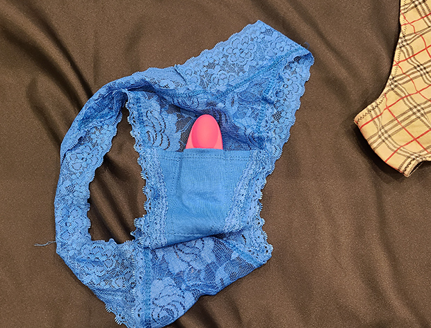 Blue lace panties with a pink vibrator on the pocket