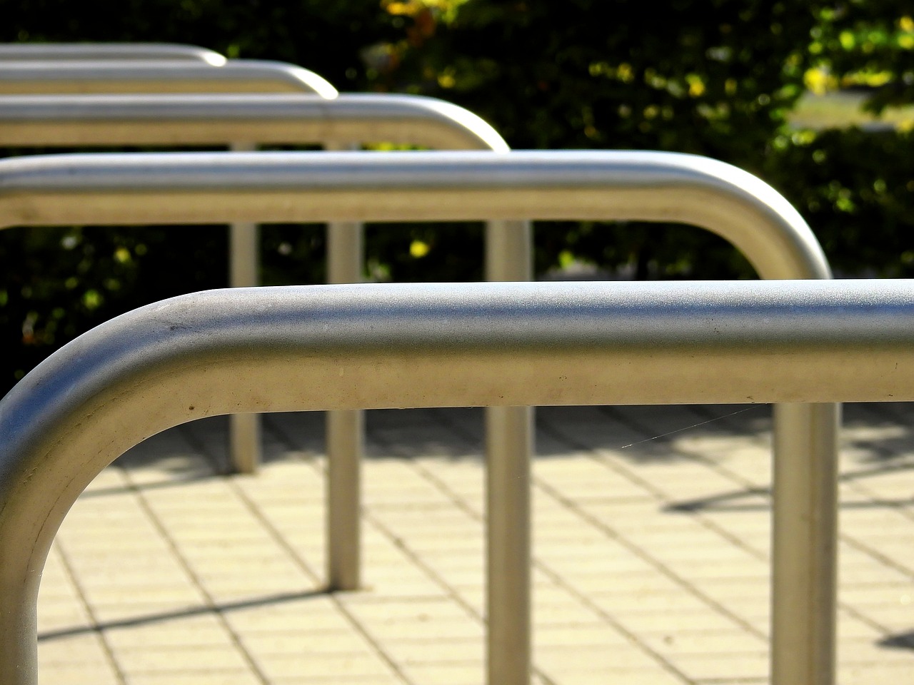 Five unpainted metal tube designed for public bike parking