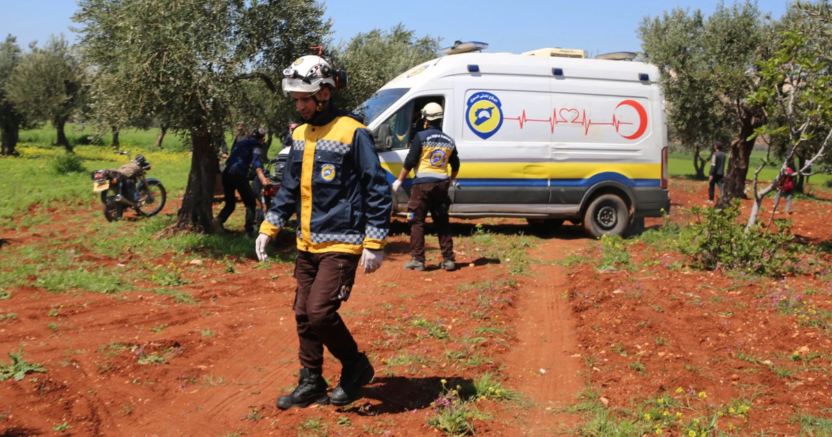 Syrian White Helmets with an ambulance in the background